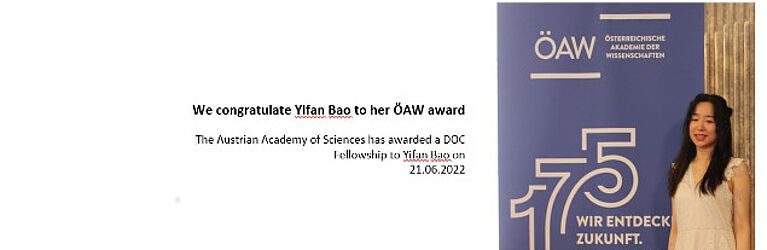 Yifan Bao steht vor dem ÖAW Auszeichnungsplakat